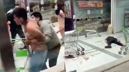 Uno de los empleados de seguridad del supermercado yace herido mientras se llevan al agresor
