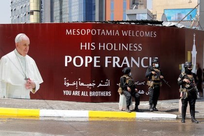 Fuerzas de seguridad frente a una pancarta que dice: "La Mesopotamia le da la bienvenida al Papa Francisco" en Baghdad (REUTERS/Khalid al-Mousily)