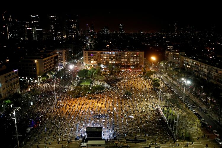 Unos dos mil israelíes se concentraron en la plaza Rabin de Tel Aviv en la noche del domingo para protestar contra el premier Benjamin Netanyahu pero portando mascarillas y manteniendo la distancia social (Reuters)