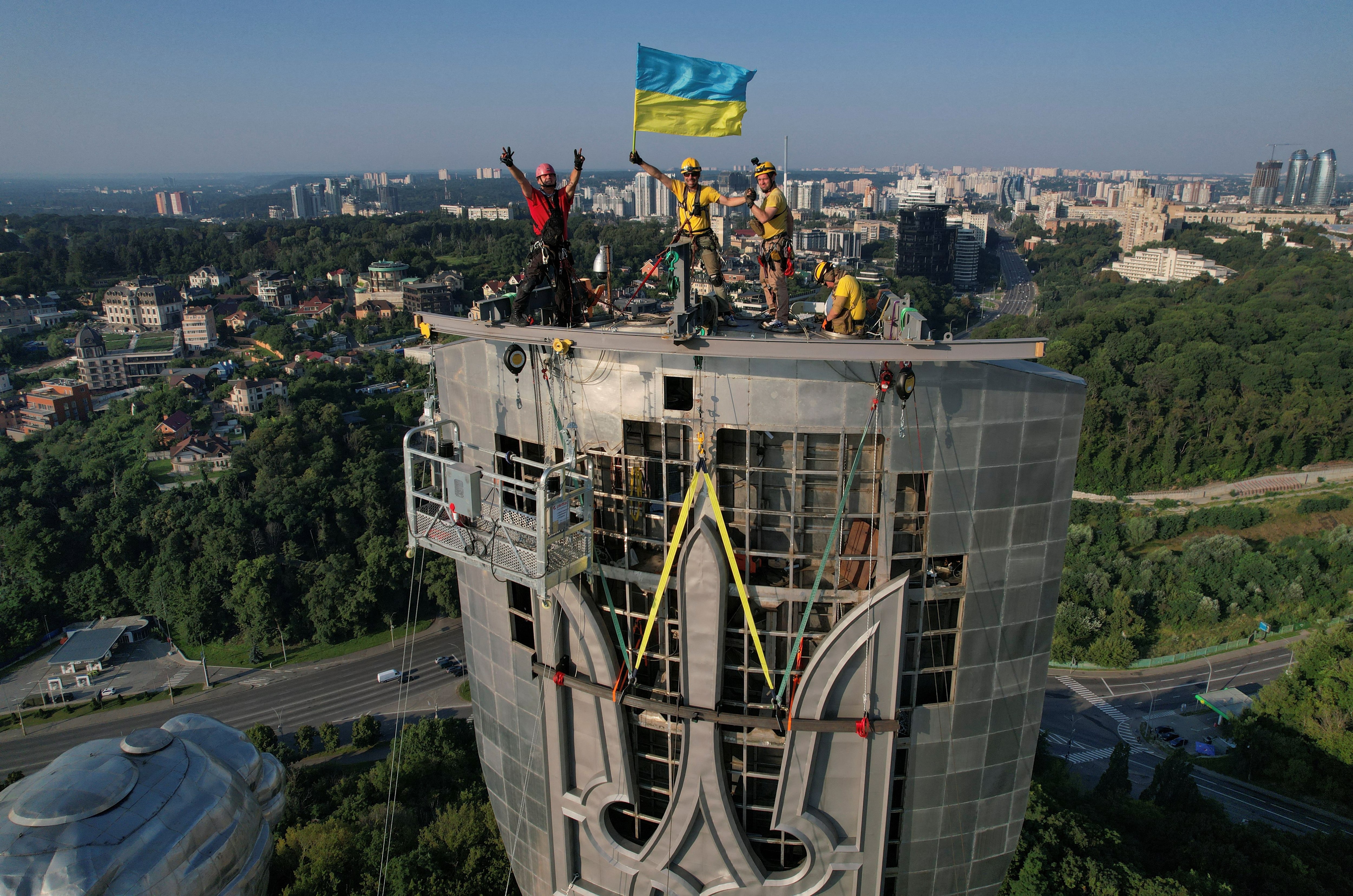 Trabajadores celebran la colocación del escudo (Reuters)