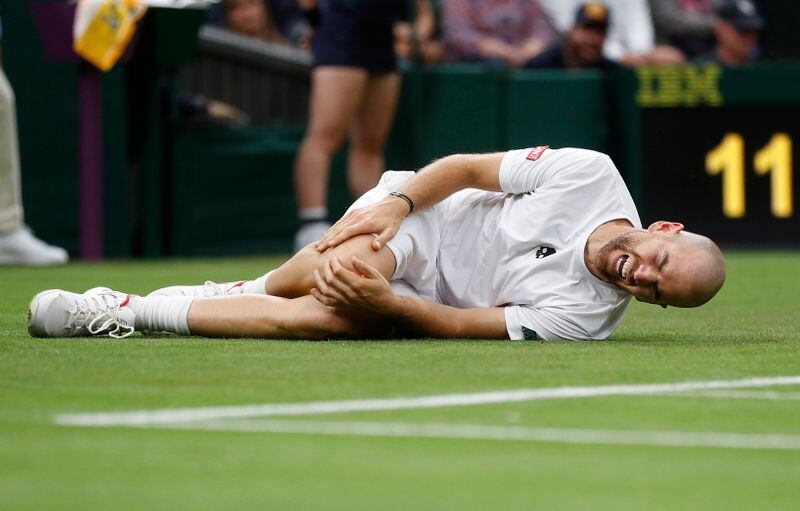 Adrian Mannarino, caído después de sufrir una lesión en el partido contra Roger Federer (Foto: Reuters)