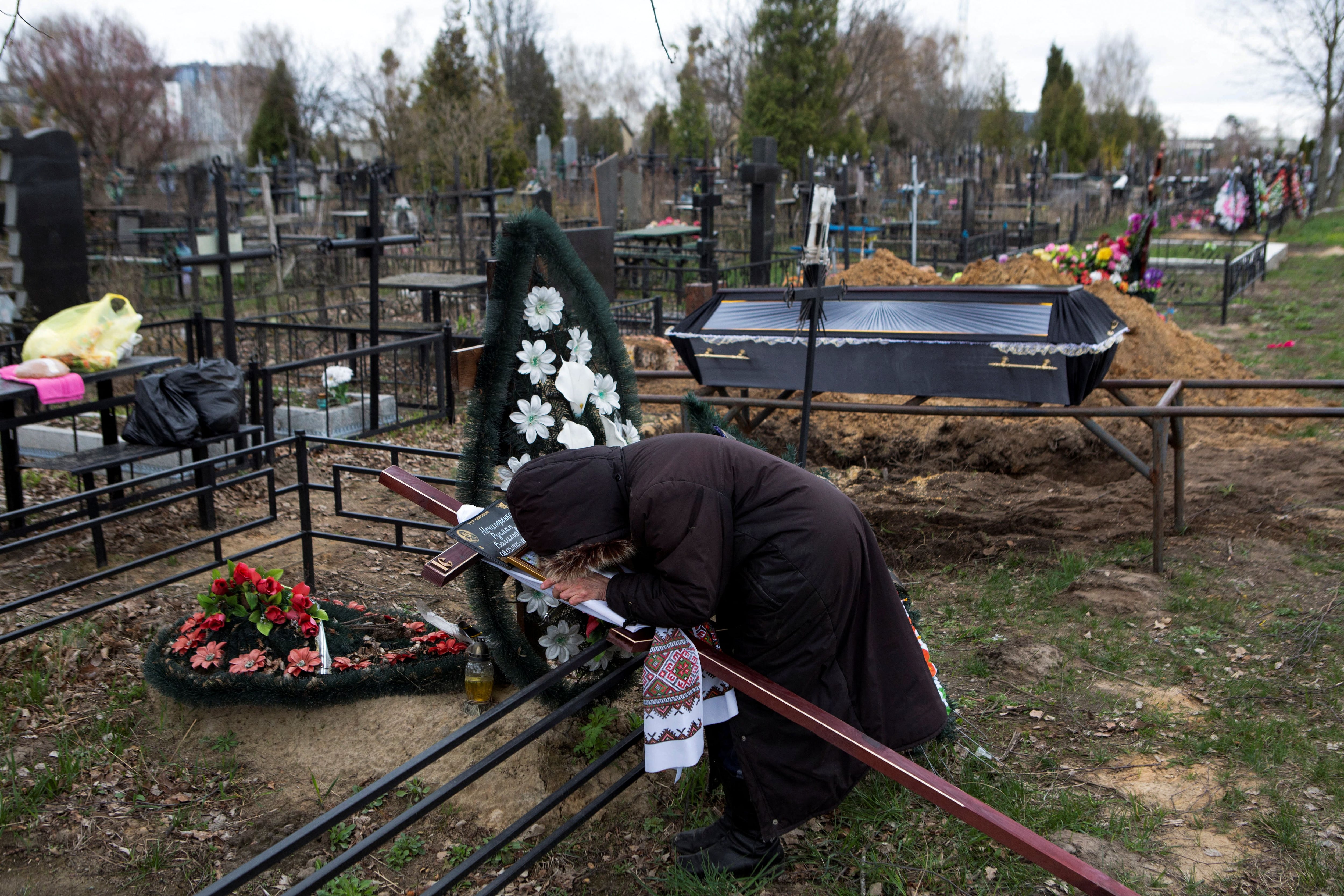 Una mujer llora durante el funeral de una víctima de la invasión en Bucha (Reuters)
