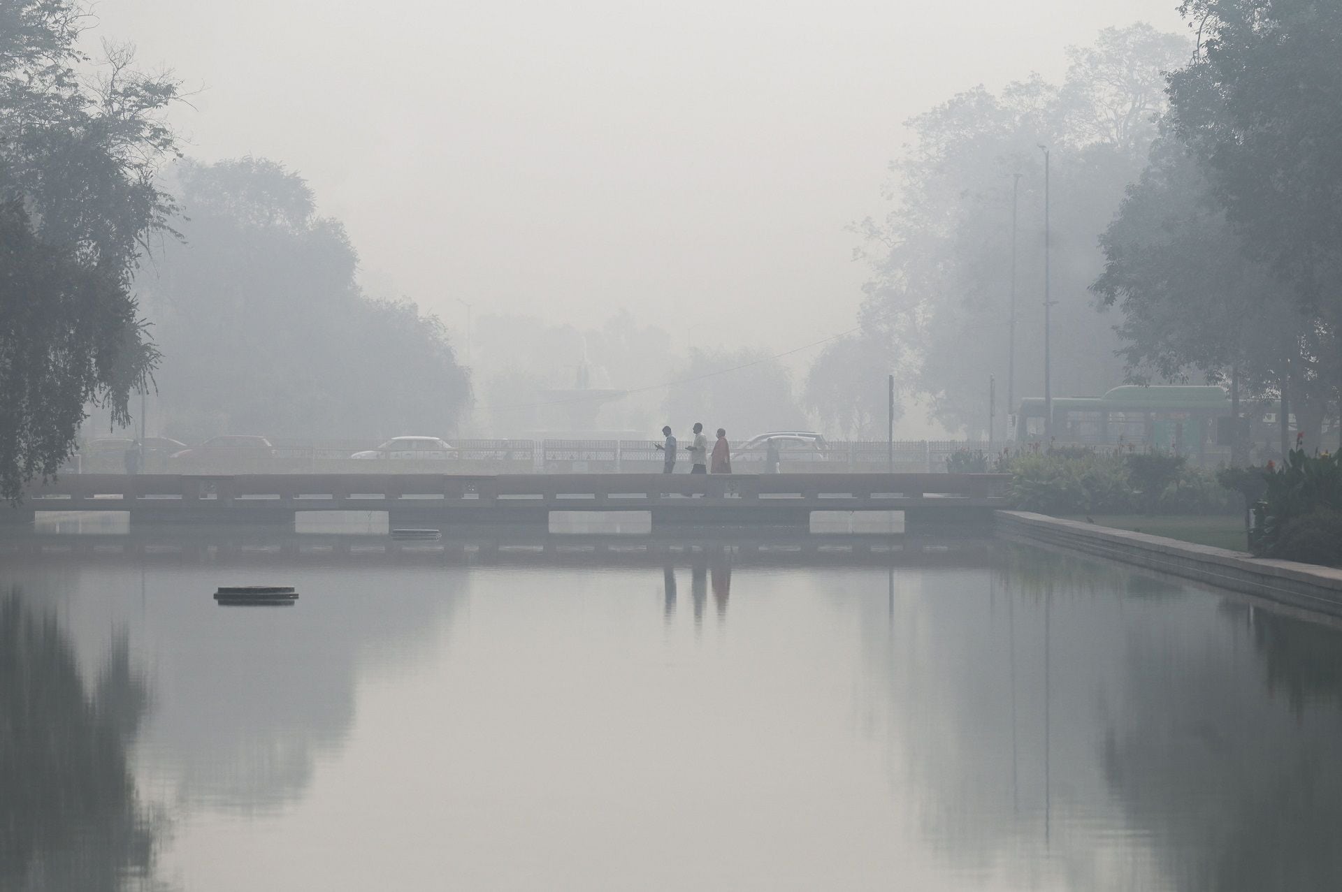 Pedestrian walk along a road near India Gate (unseen) amid heavy smog in New Delhi on November 3, 2022. (Photo by Money SHARMA / AFP)