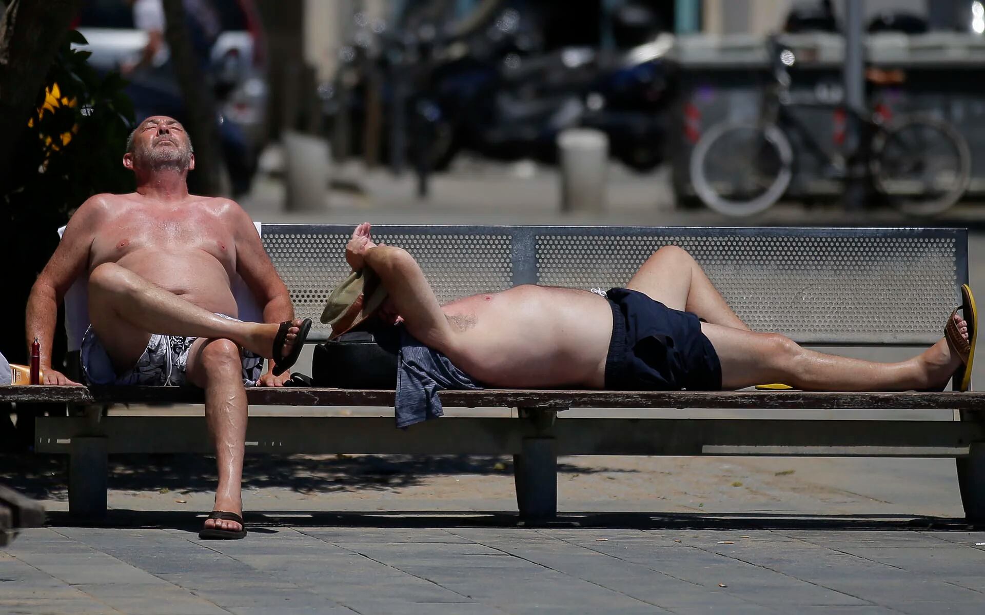 Dos hombres disfrutan del sol en la playa de Barceloneta en Cataluña