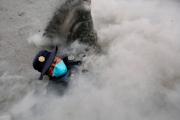 Un policía cae mientras escapa de una nueva expulsión de flujo piroclástico  (Reuters/ Luis Echeverria)