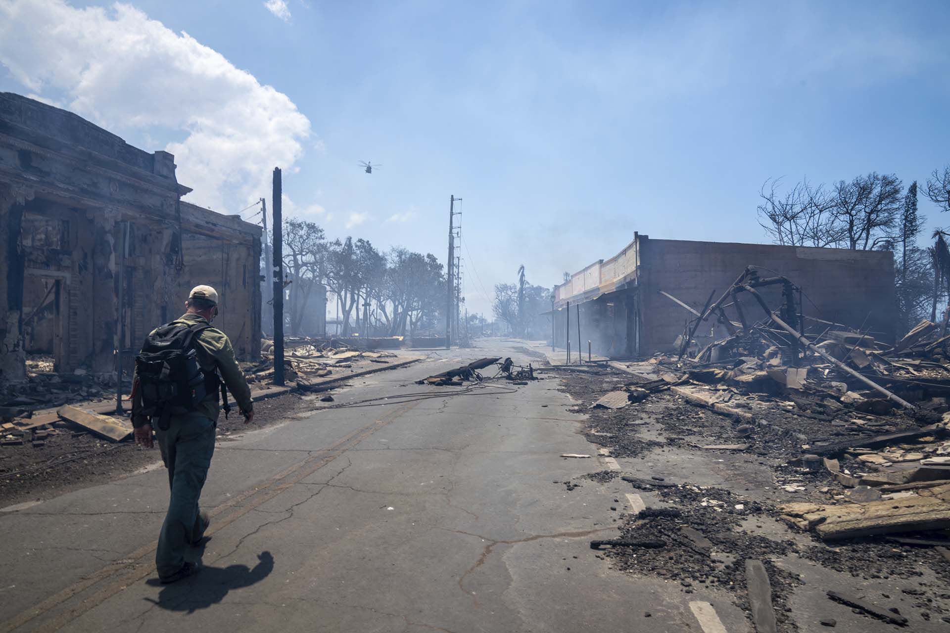 Un hombre camina junto a los restos del incendio forestal el miércoles 9 de agosto de 2023 en Lahaina, Hawaii (Tiffany Kidder Winn vía AP)