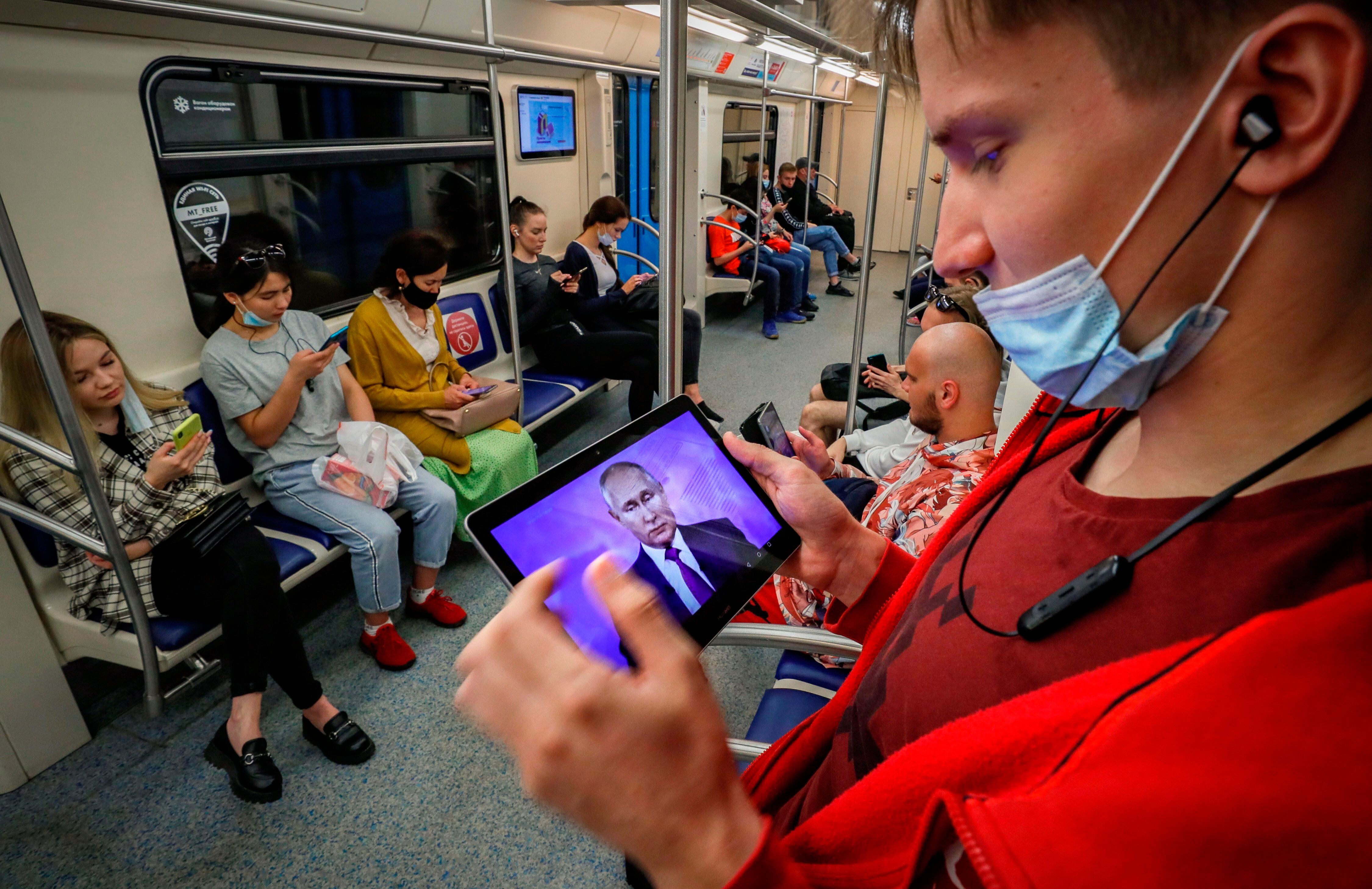 Pasajeros del metro de Moscú siguen a través de sus dispositivos móviles una intervención del presidente de Rusia, Vladímir Putin. EFE/ Yuri Kochetkov
