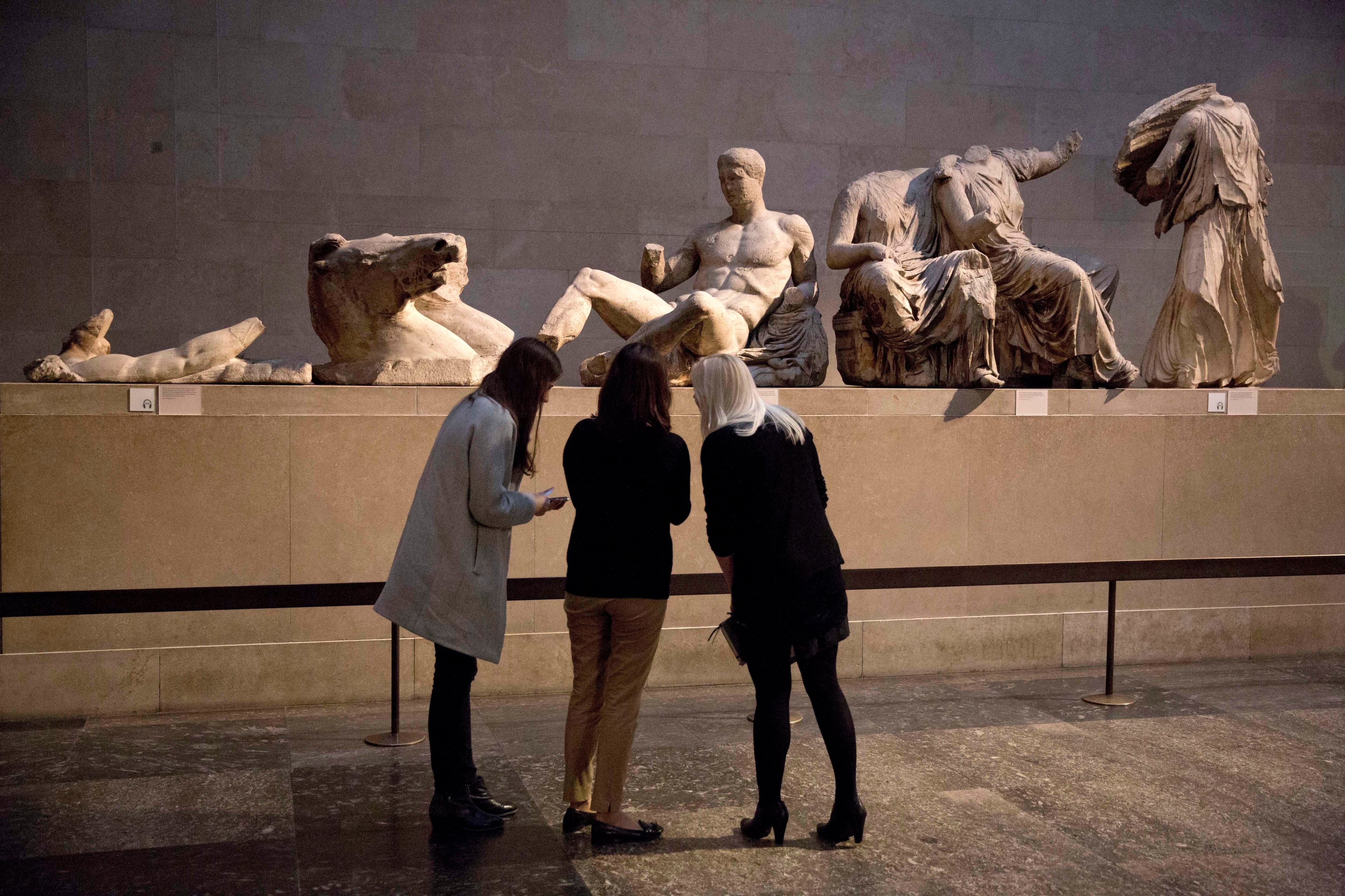 Una escultura de mármol de un joven desnudo, considerada una representación del dios griego Dionisios, centro, del frontón este del Partenón, en el Museo Británico (AP/Matt Dunham, archivo)