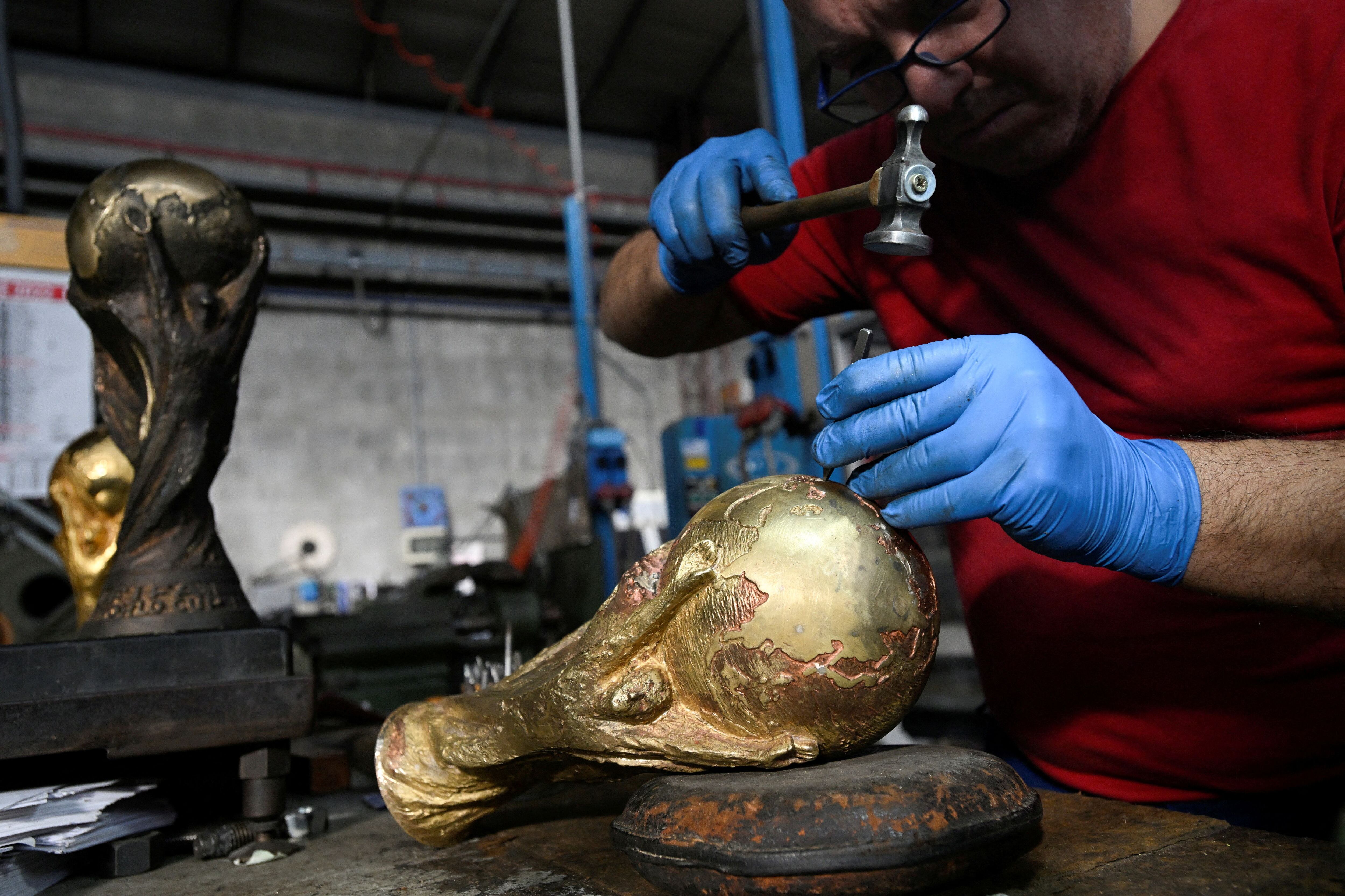 Trabajadores trabajan sobre una réplica de la Copa en la fábrica (REUTERS/Flavio Lo Scalzo)