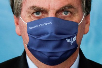 El presidente de Brasil, Jair Bolsonaro, usa una máscarilla con su nombre durante una ceremonia para anunciar inversiones para el Programa Aguas Brasileiras (programa agua brasileña) en el Palacio Planalto en Brasilia, Brasil. 22 de marzo de 2021. REUTERS/Ueslei Marcelino