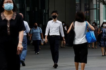 Los transeúntes con máscaras en una calle del centro financiero de Singapur