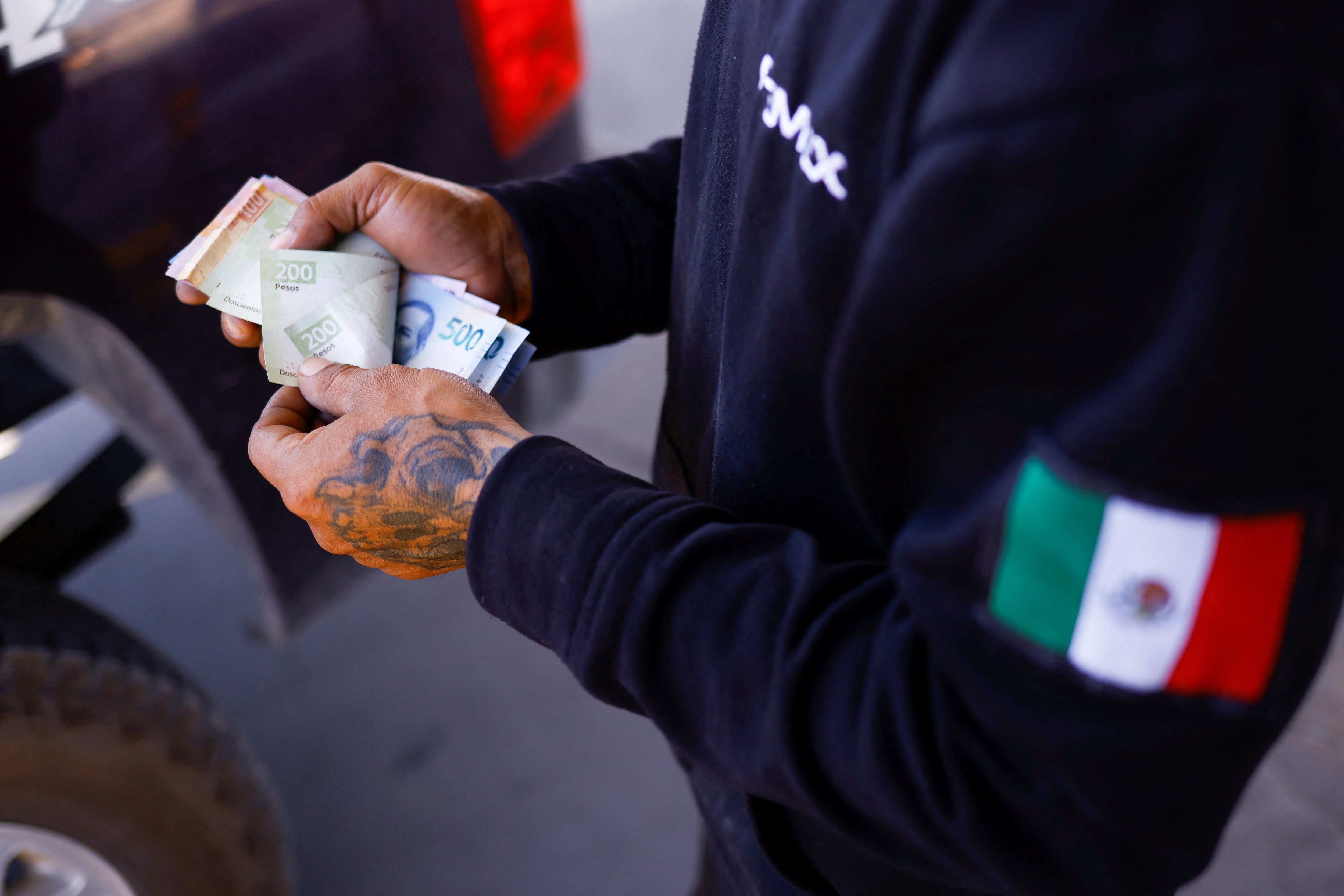 Un trabajador cuenta dinero de la venta de gasolina en una estación de servicio de CD. Juárez (Foto: Reuters)