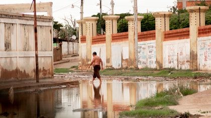 Un hombre camina en una calle inundada por las fuertes lluvias en Maracaibo (EFE/ Henry Chirinos)
