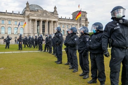 Policías con máscaras protectoras hacen guardia ante una protesta contra las restricciones del gobierno tras el brote de la enfermedad coronavirus (COVID-19) frente al Reichstag, en Berlín, el 16 de mayo de 2020 (REUTERS/Fabrizio Bensch)