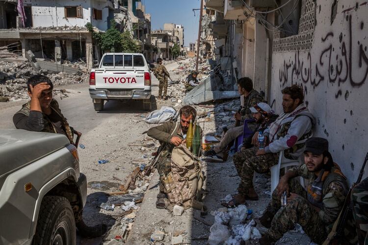Los miembros de las Fuerzas Democráticas Sirias, una milicia compuesta por kurdos y árabes sirios, descansan en una posición detrás de la primera línea en Raqqa, la autoproclamada capital del grupo del Estado Islámico. (Ivor Prickett/The New York Times)