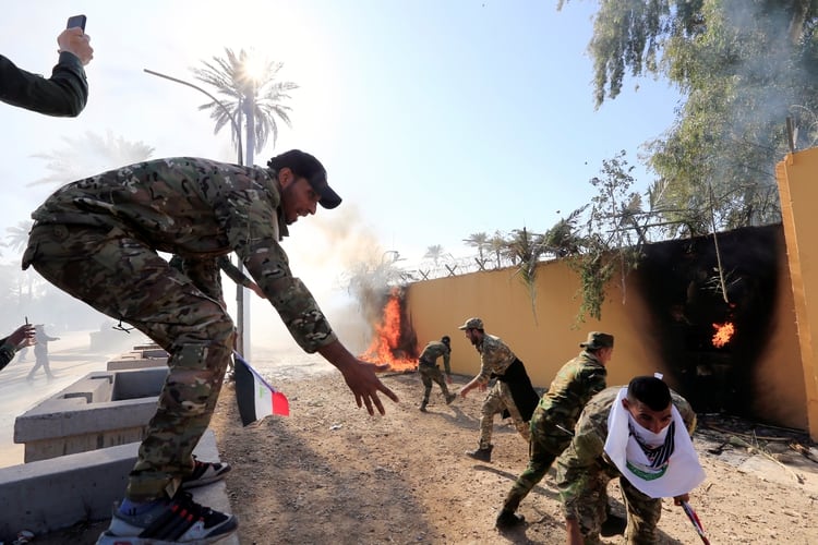 Los manifestantes están vestidos con el uniforme de combatientes de las Fuerzas de Movilización Popular (REUTERS/Thaier al-Sudani)