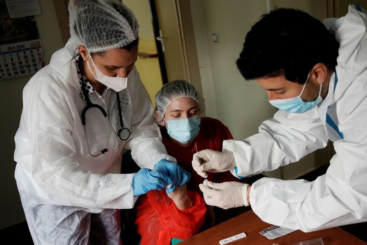 Trabajadores de la salud realizan un análisis de sangre para la enfermedad coronavirus (COVID-19) durante el confinamiento en medio del brote de la enfermedad coronavirus (COVID-19) en el asilo de ancianos Las Praderas en Pozuelo de Alarcón, España, el 23 de abril de 2020. REUTERS/Juan Medina