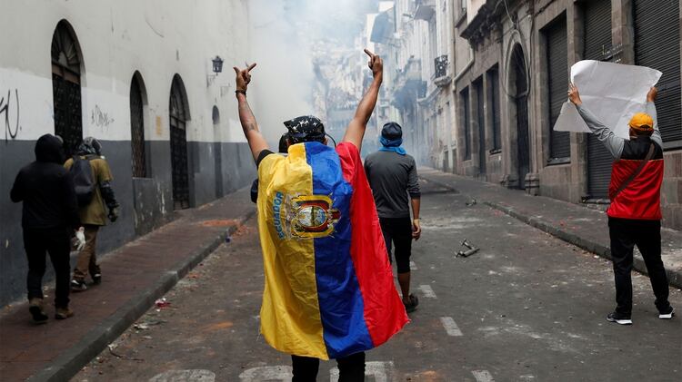 Un manifestante cubierto con una bandera ecuatoriana reacciona durante una protesta contra las medidas de austeridad del presidente de Ecuador, Lenin Moreno, en Quito (Reuters)