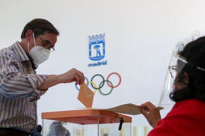 Un hombre con mascarilla vota en las elecciones regionales de Madrid. REUTERS/Susana Vera