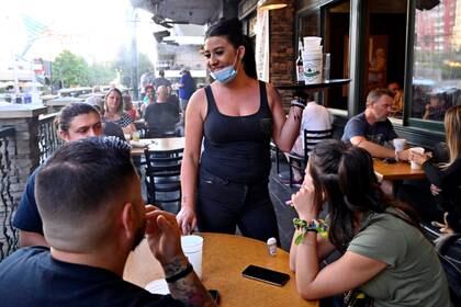 La camarera Timi Sánchez espera a los clientes en Hennessey's Tavern mientras los restaurantes abren sus puertas en las aceras y las restricciones para prevenir la propagación de la enfermedad del coronavirus (COVID-19) se suavizan en Las Vegas, Nevada, EE.UU., el 15 de mayo de 2020 (Reuters)