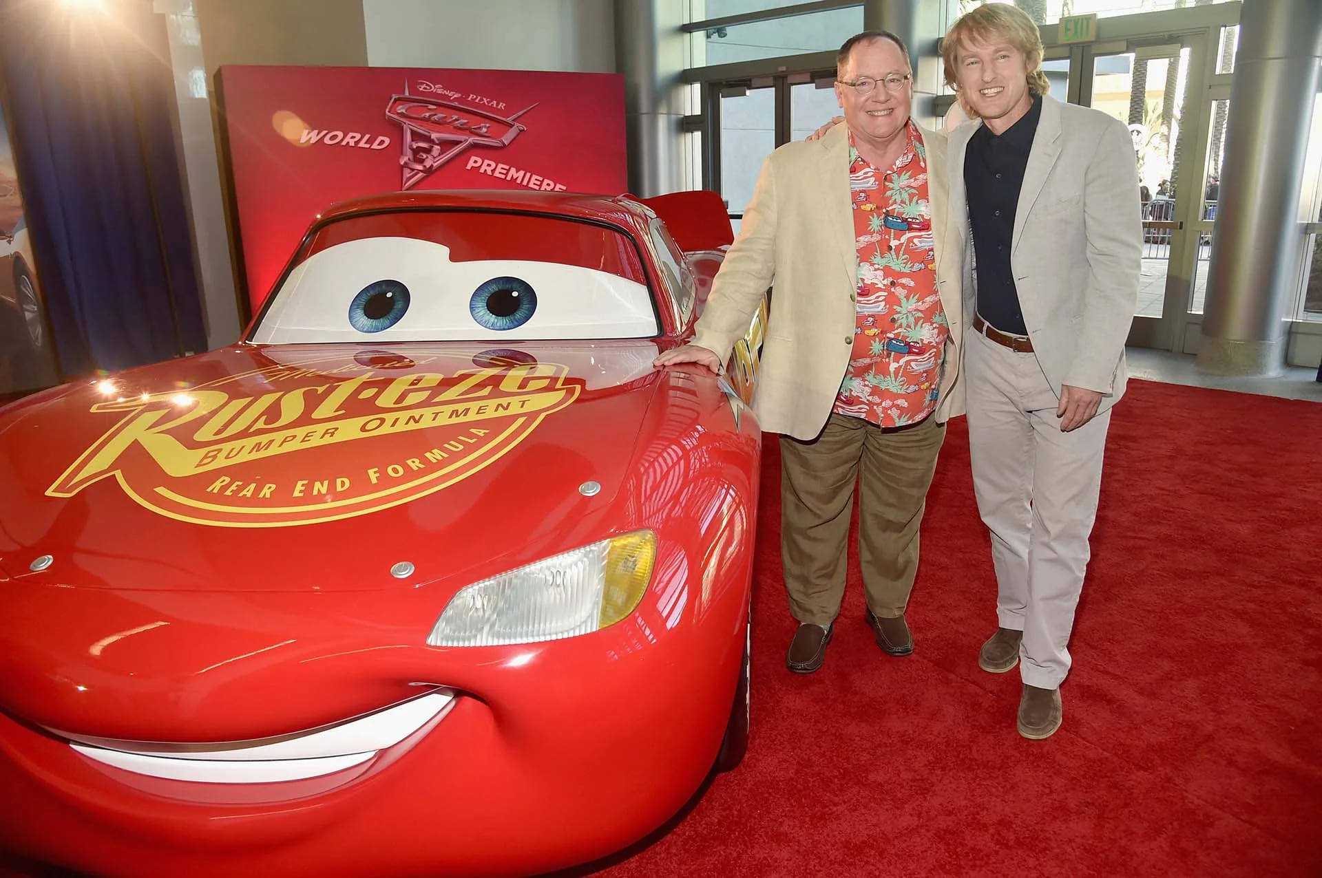 El productor ejecutivo John Lasseter junto a Owen Wilson