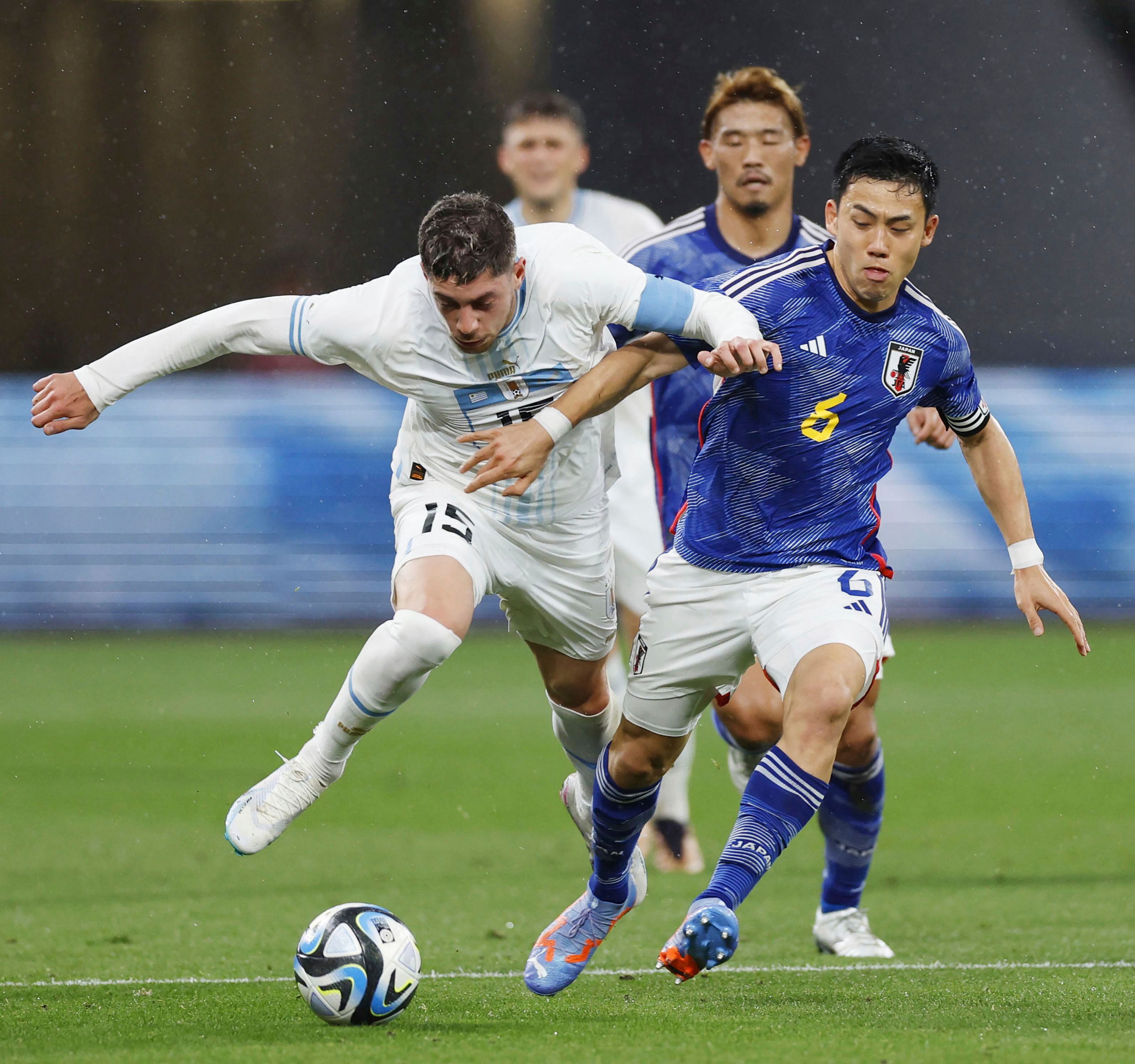 Federico Valverde de Uruguay y Wataru Endo de Japón pelean por el balón en el encuentro amistoso en el Estadio Nacional de Tokio, Japón el viernes 24 de marzo del 2023. (Kyodo News via AP)