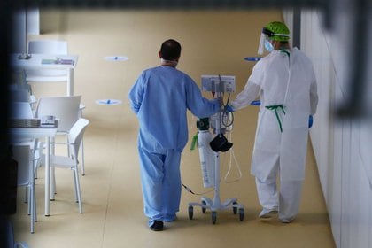 Trabajador camina con un paciente de COVID-19 en hospital Enfermera Isabel Zendal, Madrid, España, 29 enero 2021.
REUTERS/Sergio Pérez
