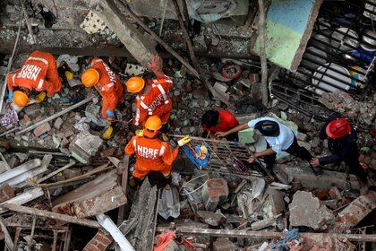 Equipos de rescate y bomberos retiran escombros mientras buscan sobrevivientes tras el derrumbe de un edificio residencial de tres pisos en Bhiwandi, en las afueras de Mumbai, India (REUTERS/Francis Mascarenhas)