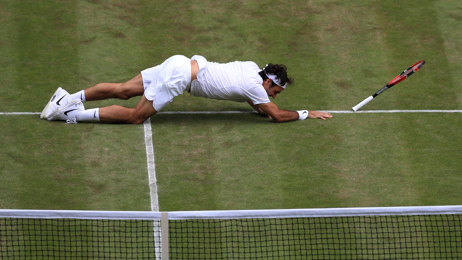 Federer sufrió una dura caída en el quinto set ante Raonic (AFP)