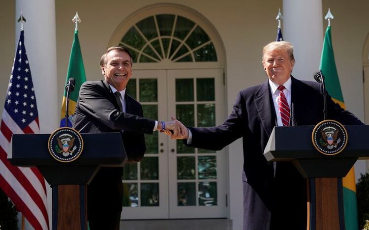 El presidente de Brasil Jair Bolsonaro se da la mano con su par estadounidense Donald Trump en una conferencia de prensa conjunta en el Rose Garden de la Casa Blanca en Washington, el 19 de marzo de 2019 (Reuters)