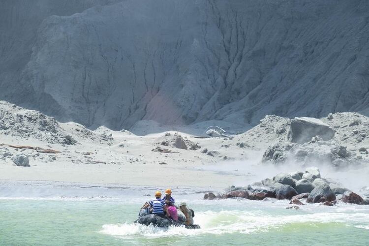 Imagen obtenida en las redes sociales que muestra a guías turísticos evacuando a personas en un bote poco después de la erupción volcánica en White Island, Nueva Zelanda. 9 diciembre 2019. (@SCH/vía Reuters)