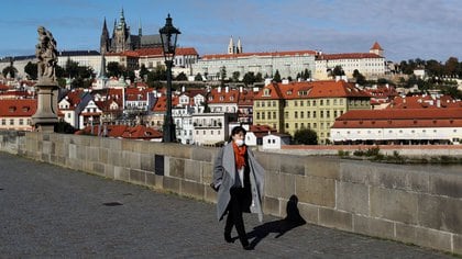 Una mujer con una máscara facial camina por el medieval Puente de Carlos, mientras el gobierno checo cierra los deportes, la cultura y los lugares sociales durante dos semanas para frenar la propagación del COVID-19, en Praga, República Checa, el 12 de octubre de 2020. REUTERS/David W Cerny