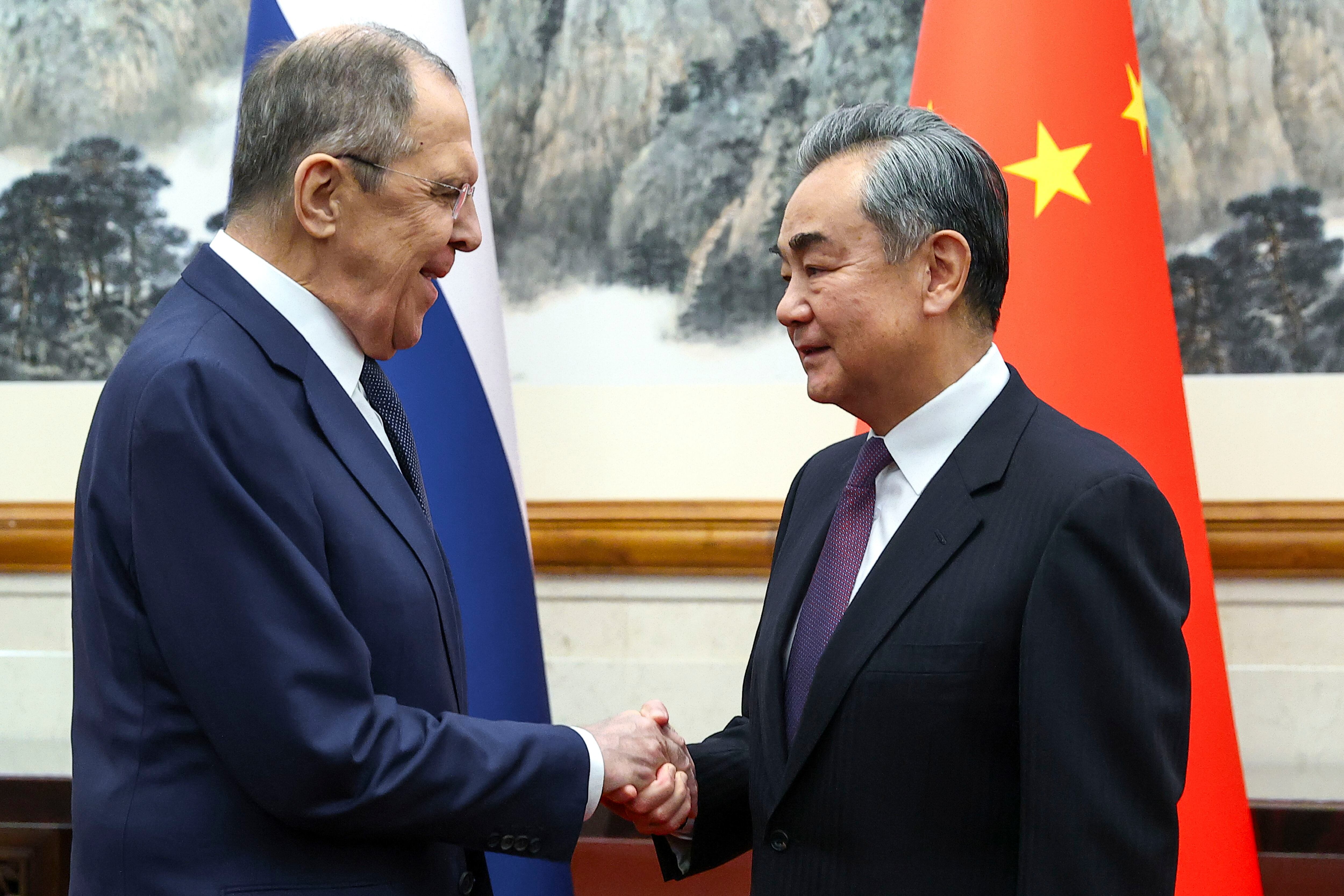 El ministro ruso de Exteriores, Serguéi Lavrov, a la izquierda, y el ministro chino de Exteriores, Wang Yi, se estrechan la mano antes de su reunión en Beijing, China. (Servicio de prensa del Ministerio ruso de Exteriores via AP)