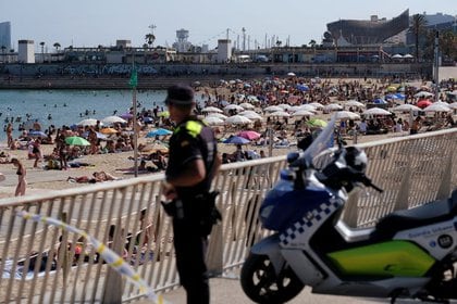 Foto de archivo de un oficial de policía mirando al público disfrutando de un día en la playa de Barcelona.  21 de junio de 2020. REUTERS / Nacho Doce