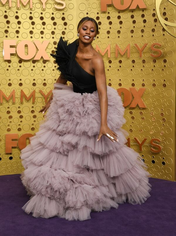 Con una falda vaporosa de tul,  Laverne Cox llegó a la alfombra violeta de los Emmy Awards. Completando su look con la parte superior con un corsé negro. Completó el estilismo con un maxi anillo blanco y aros pequeños