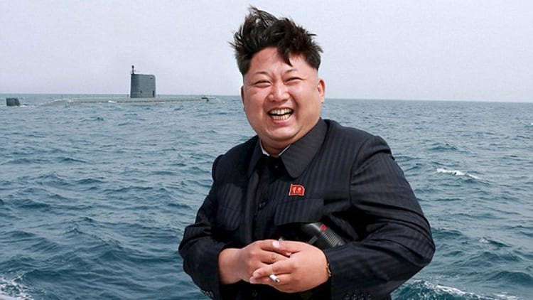 Una foto de archivo muestra a Kim sonriendo, con un submarino en la distancia (Reuters)