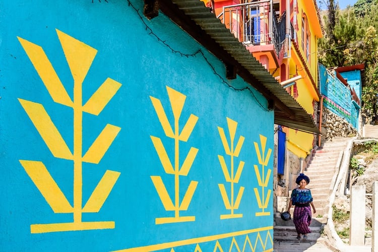 En las orillas del lago de Atitlán en Guatemala se encuentra la ciudad recién pintada de Santa Catarina Palopó. Sus 5.000 residentes mayas solían ganarse la vida con la agricultura y la pesca, pero han recurrido al turismo desde que su tierra cultivable comenzó a engullirse por la expansión urbana. El proyecto de pintura de Santa Catarina Palopó, comenzó en 2016 y alienta a los residentes a pintar sus casas con los motivos tradicionales que se ven en las blusas tejidas guatemaltecas