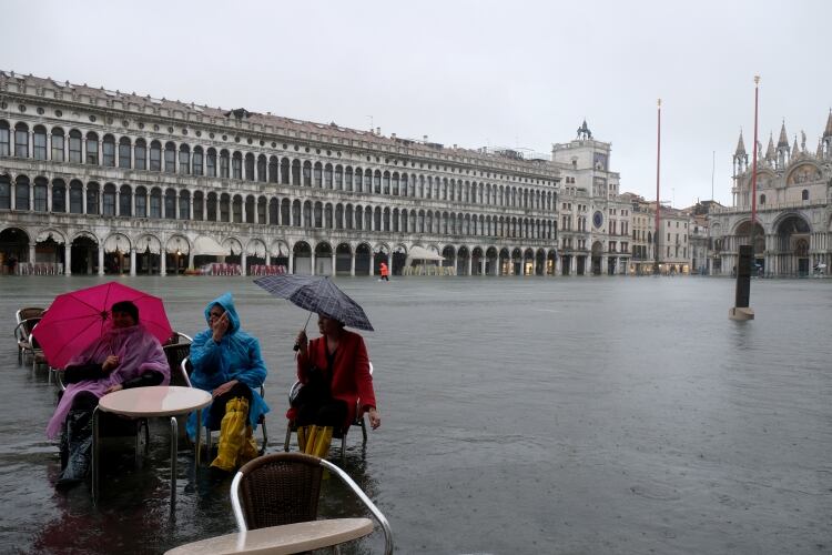 Los turistas se sientan en la Plaza de San Marcos inundada el 12 de noviembre de 2019 (REUTERS/Manuel Silvestri)