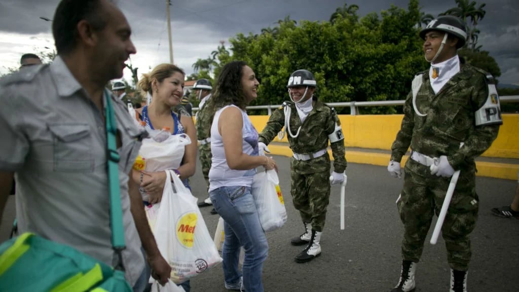 Los venezolanos saludan a la policía colombiana en la frontera (AP)