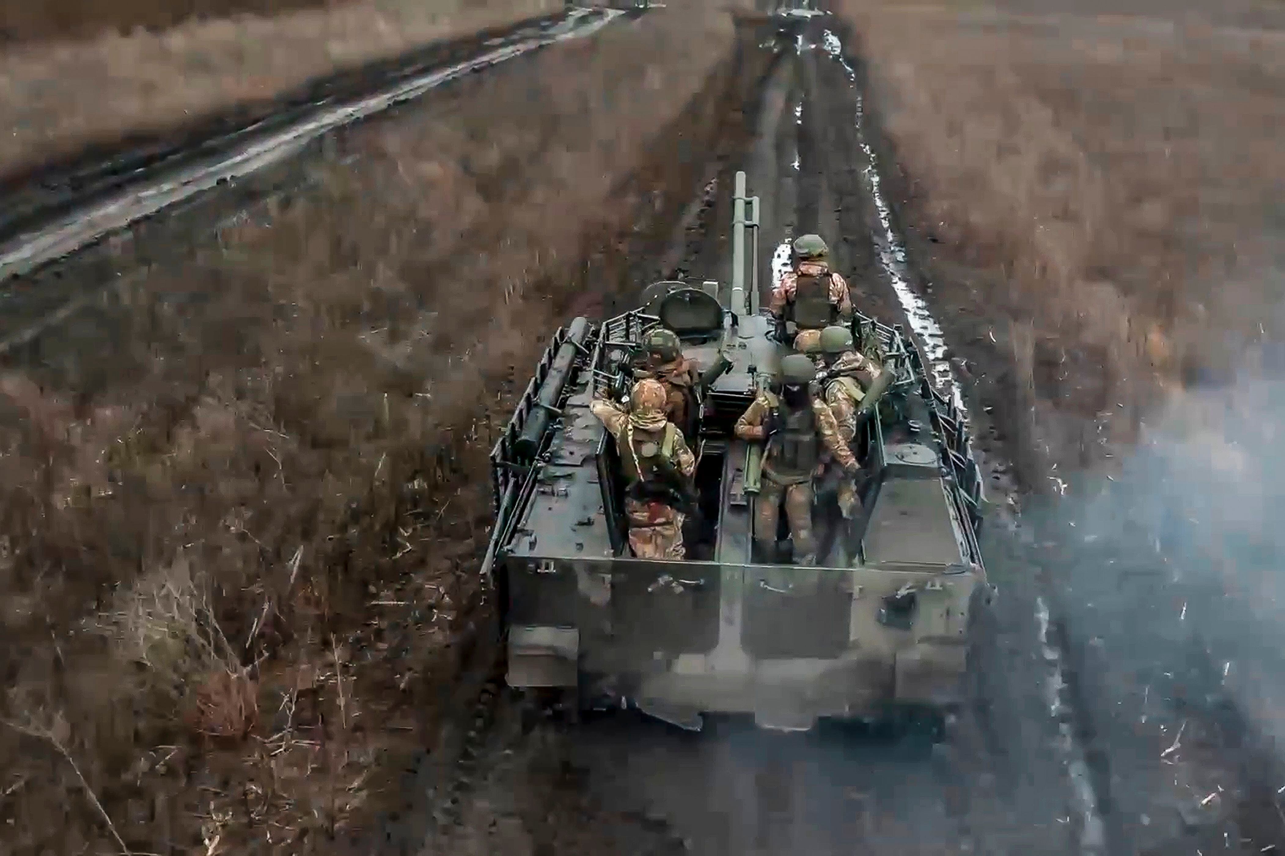 Soldados rusos avanzan en un vehículo blindado para tomar posiciones y disparar contra posiciones ucranianas, en un lugar no identificado de Ucrania. (Servicio de prensa del Ministerio de Defensa de Rusia vía AP)
