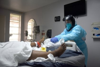 Una trabajadora atiende a un paciente con covid-19