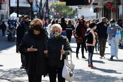 Personas de todas las edades salen a pasear durante un día soleado en Quilmes. Si bien el uso del tapabocas está generalizado, la distancia social es cosa del pasado. No se ve control policial ni de las autoridades municipales, aunque hay presencia de efectivos de la fuerza de seguridad local cada cierto número de cuadras