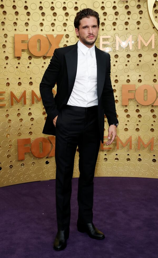 Kit Harington, el protagonista de Game of Thrones se lució en la alfombra violeta con un esmoquin de saco, camisa y pantalón, sin corbata ni moño y completó su look con zapatos de cuero