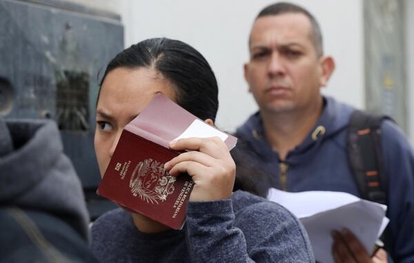 Una inmigrante venezolana tapa su rostro con un pasaporte antes de presentarse ante las autoridades de inmigraciÃ³n peruanas. (REUTERS/Mariana Bazo)