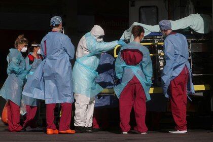 Personal médico con ropa de protección saca a un paciente de una ambulancia en el hospital de Santo Tomás, Londres, Reino Unido. 31 de marzo de 2020. REUTERS/Hannah McKay
