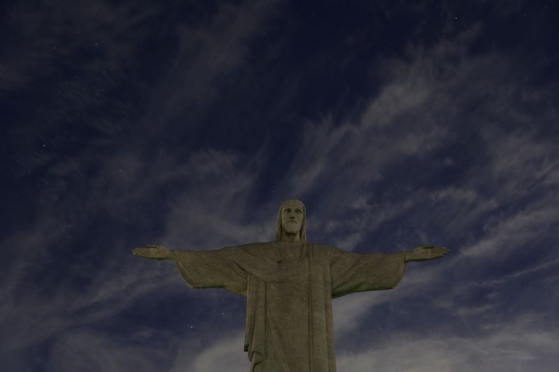 El Cristo Redentor tiene sus luces apagadas para condenar los "ataques racistas" a la estrella del fútbol brasileño Vinicius Jr en España, en Río de Janeiro, Brasil. 22 de mayo 2023 (REUTERS/Pilar Olivares)