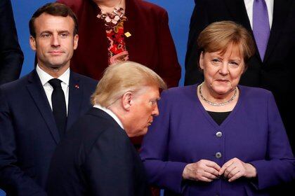 El presidente de Francia Emmanuel Macron y la canciller de Alemania Angela Merkel miran al presidente Donald Trump durante una foto de familia en la cumbre de líderes de la OTAN en Watford, Reino Unido, el 4 de diciembre de 2019 (REUTERS/Christian Hartmann/Pool/File Photo/File Photo)