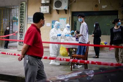 Trabajadores sanitarios en trajes de protección realizan pruebas de ácido nucleico a los residentes de un complejo residencial en Wuhan, la ciudad china más afectada por el brote de la enfermedad coronavirus (COVID-19), en la provincia de Hubei, China, el 15 de mayo de 2020. REUTERS