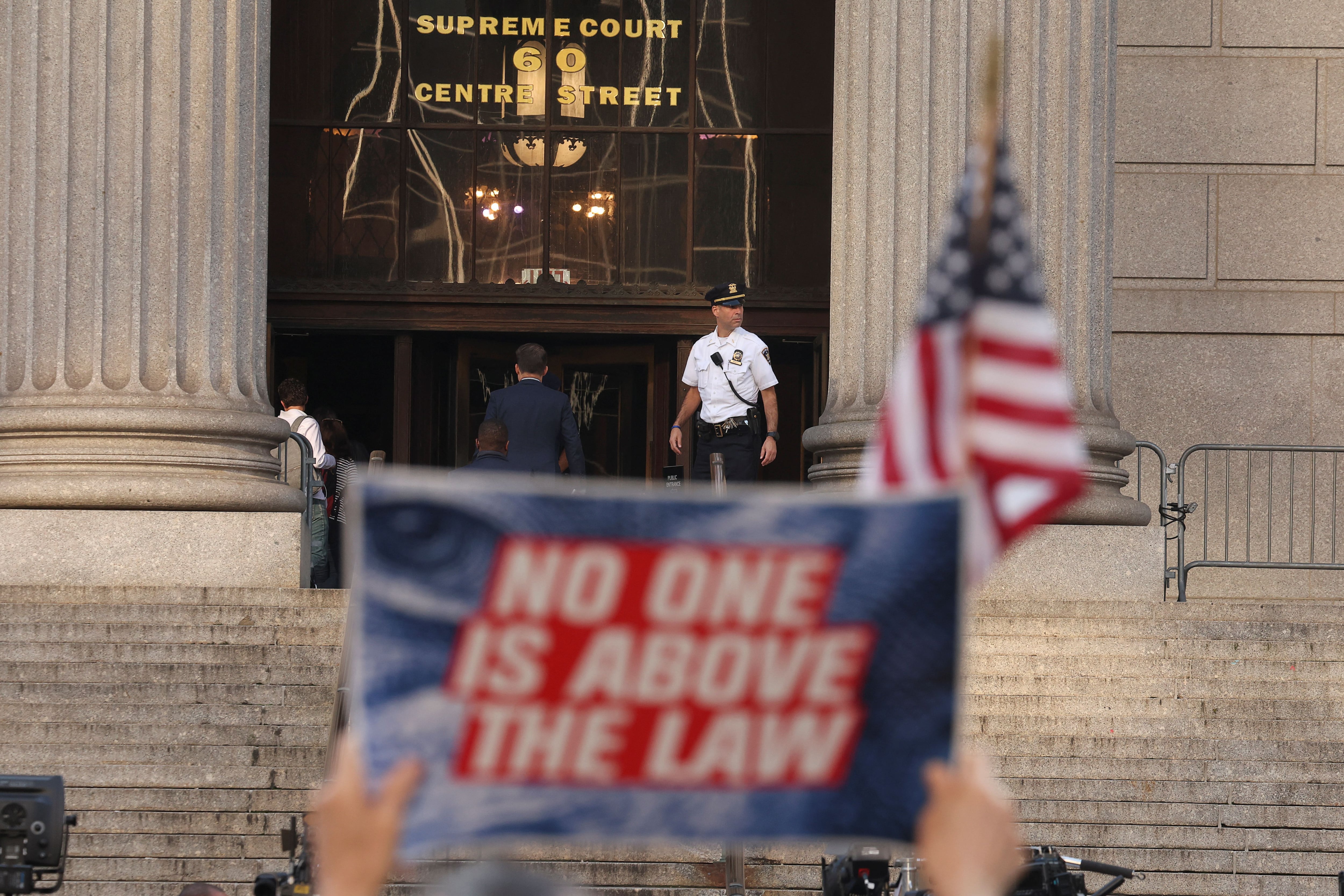 "Nadie está por encima de la ley", indica un cartel de un manifestante afuera del juzgado (Reuters)