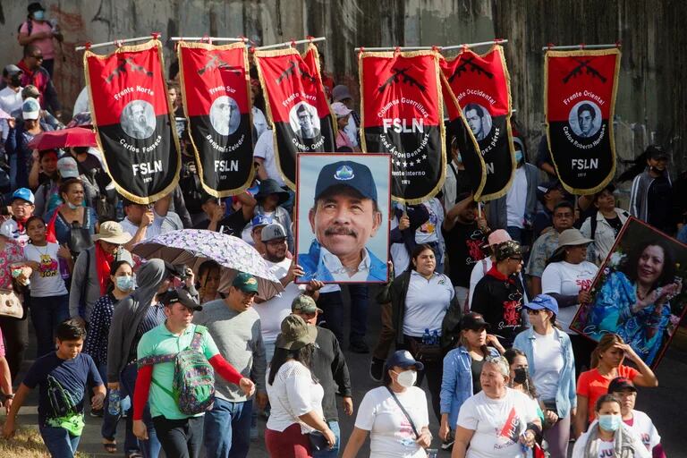  Simpatizantes portan pancartas del Frente Sandinista de Liberación Nacional y un retrato de Daniel Ortega en una marcha 